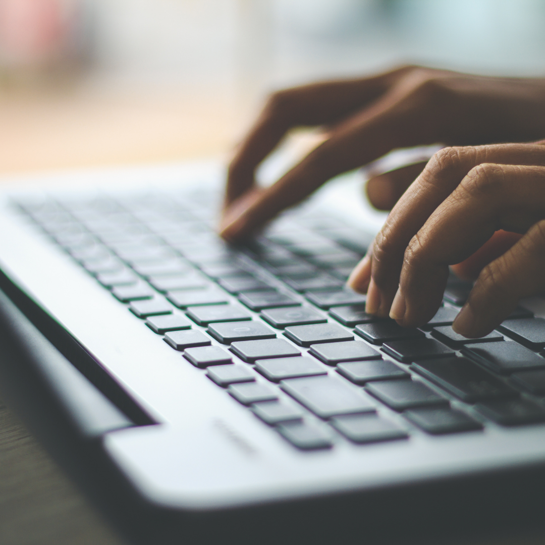 A close-up shot of a laptop and a person's hands typing on the keyboard, used to describe content marketing.